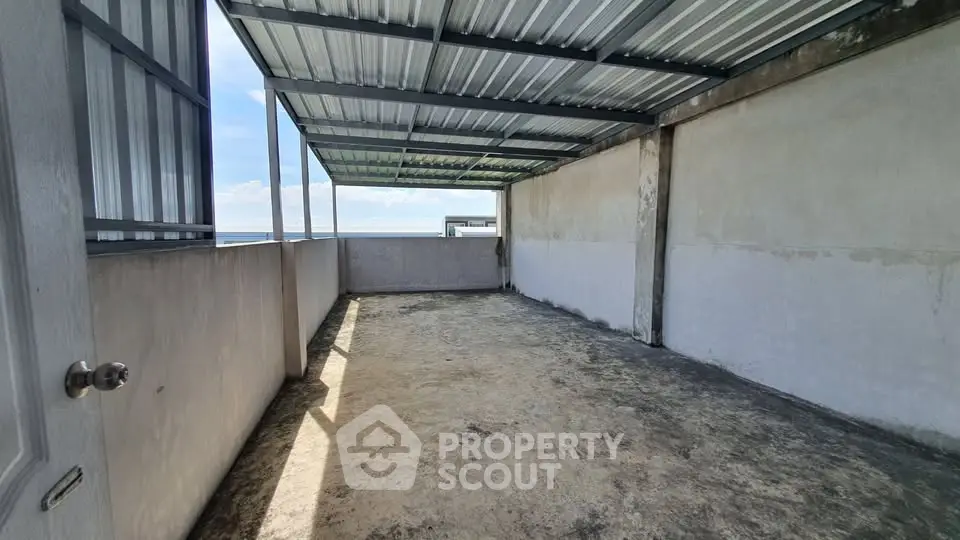 Spacious rooftop area with partial covering and ocean view, perfect for customization.