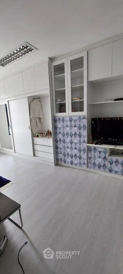 Sleek modern kitchen with stylish blue patterned backsplash, ample white cabinetry, and integrated oven, perfect for culinary enthusiasts.