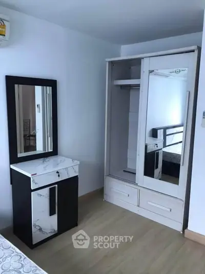 Modern bedroom with sleek wardrobe and stylish vanity in minimalist design.