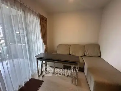 Cozy living room with modern sofa and balcony view, perfect for relaxation and entertaining guests.