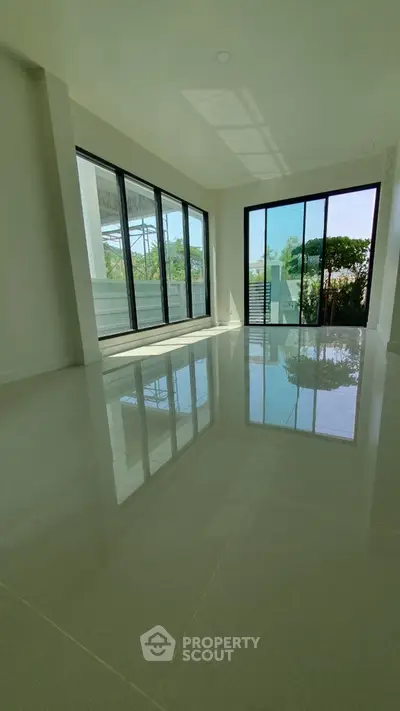 Spacious modern living room with large windows and glossy floors