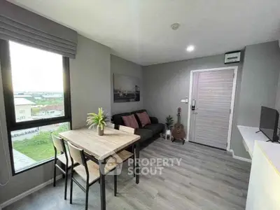 Modern living room with large window and stylish decor in a cozy apartment.