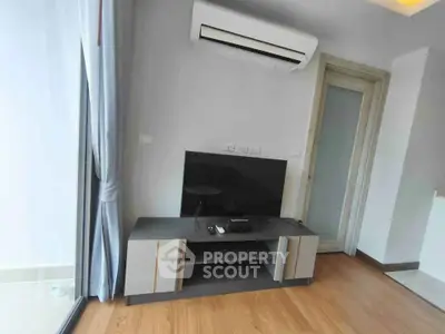 Modern living room with sleek TV setup and air conditioning in a stylish apartment.