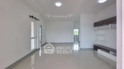 Spacious modern living room with sleek tile flooring and built-in shelving.