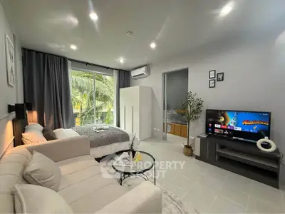 Modern studio apartment with cozy living area and bedroom, featuring a large window and stylish decor.