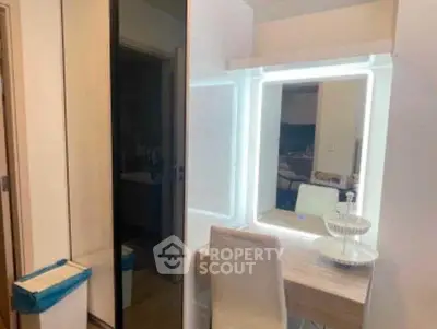 Modern bedroom with illuminated vanity and sleek storage solutions.