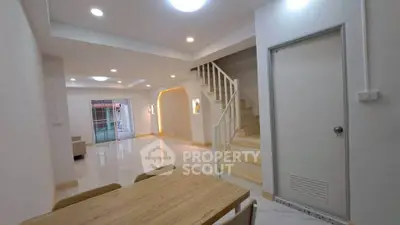 Spacious modern living area with elegant staircase and dining table, perfect for family gatherings.