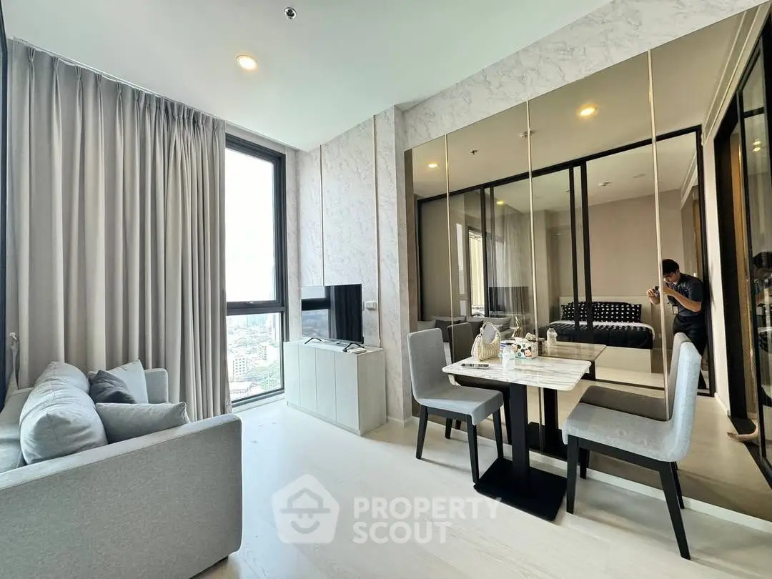 Modern living room with dining area and large windows in a stylish apartment.