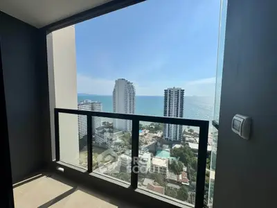 Stunning high-rise balcony view of ocean and city skyline, perfect for urban living.