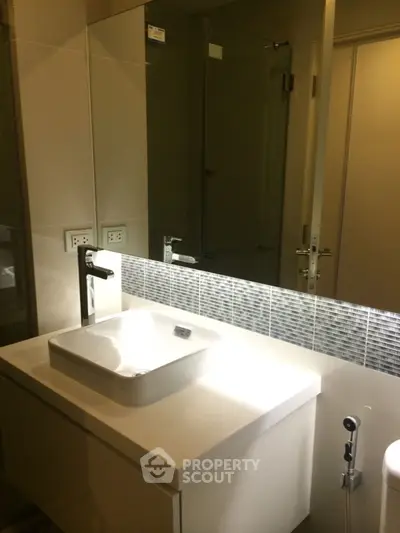 Modern bathroom with sleek sink and glass shower enclosure
