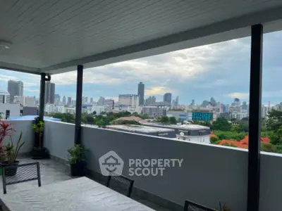 Spacious balcony with stunning city skyline view, perfect for relaxation and entertainment.
