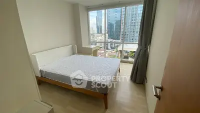 Modern bedroom with large window and city view in high-rise apartment