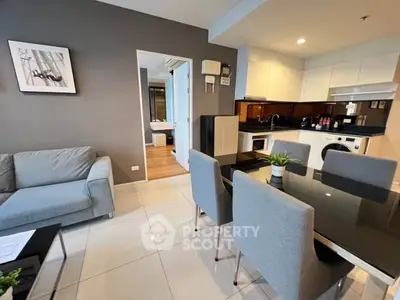 Modern open-plan living and dining area with sleek kitchen in a stylish apartment.