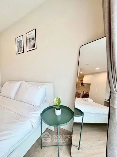 Modern bedroom with stylish decor and full-length mirror reflecting elegant design.
