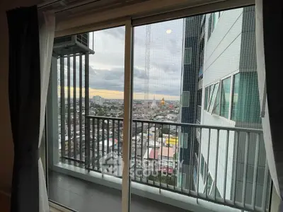 Stunning city view from high-rise apartment balcony with sliding glass doors.