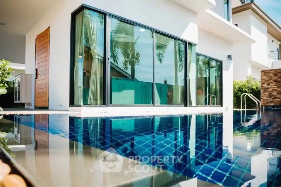 Luxurious modern villa with stunning pool and glass facade, perfect for tropical living.