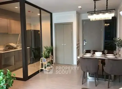 Modern open-plan kitchen and dining area with elegant decor and glass partition.