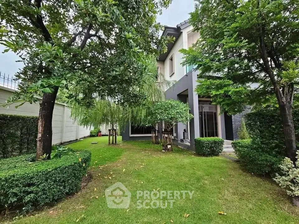 Charming garden view of modern home with lush greenery and elegant architecture.