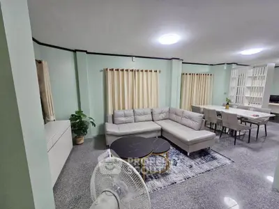 Spacious living room with modern furniture and dining area, featuring elegant decor and ample natural light.