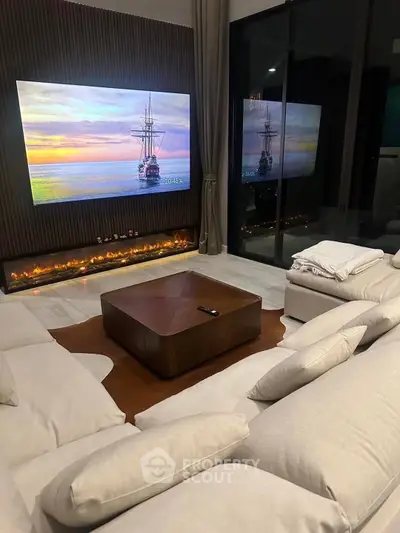 Luxurious living room with modern fireplace and large TV, perfect for relaxation and entertainment.