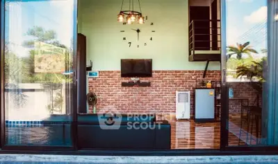 Modern living room with brick wall, stylish clock, and pool view through large glass doors.