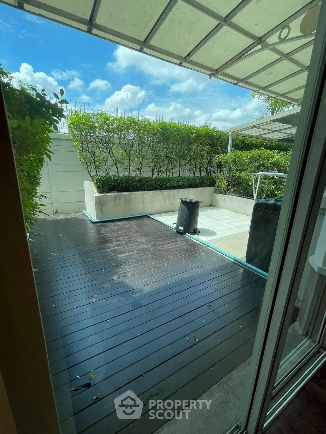 Charming garden patio with wooden deck and lush greenery, perfect for outdoor relaxation and entertainment.