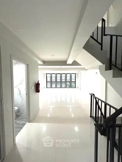 Spacious modern interior with sleek staircase and large windows, perfect for contemporary living.