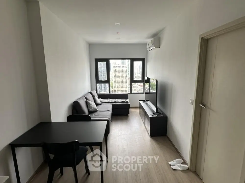 Modern living room with city view, featuring sleek furniture and minimalist design.