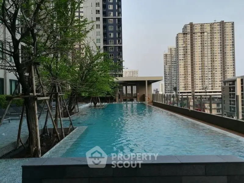Luxurious rooftop pool with city skyline views in modern high-rise building.