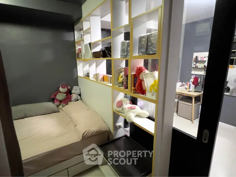 Cozy bedroom with modern shelving and plush toys, perfect for a small apartment.