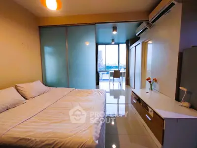 Modern bedroom with large bed, sliding glass doors, and city view.