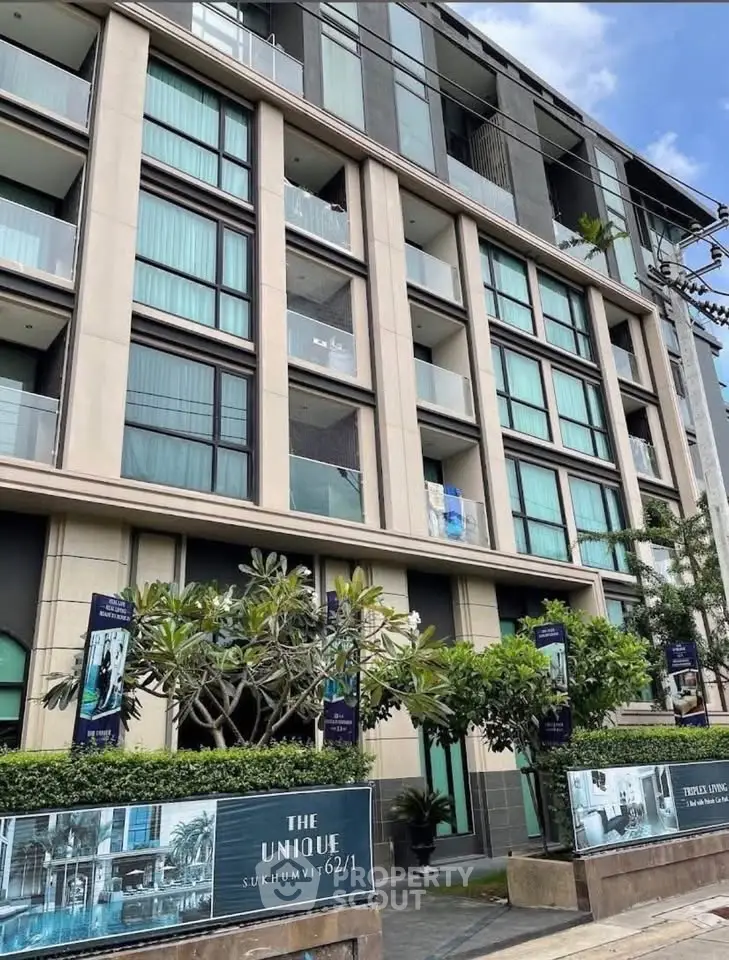 Modern condominium building with lush greenery and stylish facade in urban setting.