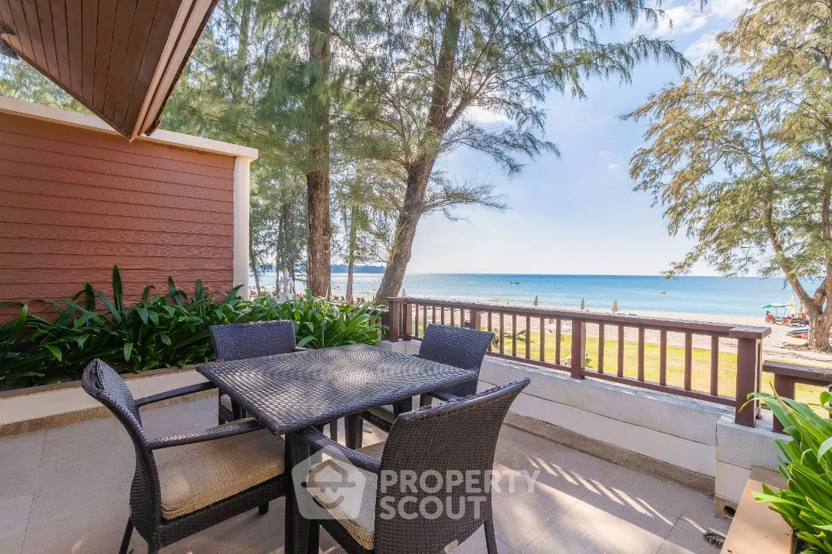 Stunning beachfront balcony with ocean view and outdoor dining set.