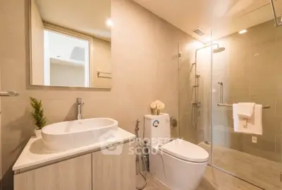 Modern bathroom with glass shower, sleek vanity, and elegant fixtures in a contemporary home.