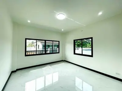 Spacious empty room with large windows and glossy tiled floor, perfect for customization.