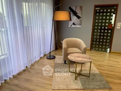 Modern living room with stylish armchair, floor lamp, and elegant decor.