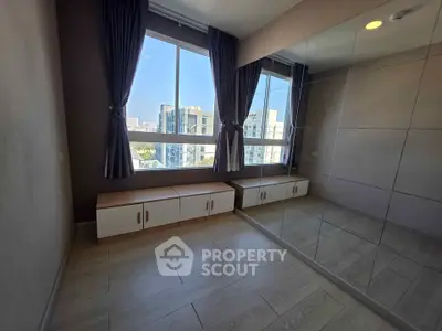 Spacious bedroom with large mirrored closet and city view window