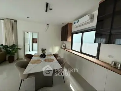 Modern kitchen with sleek design and open layout, featuring a marble dining table and contemporary decor.