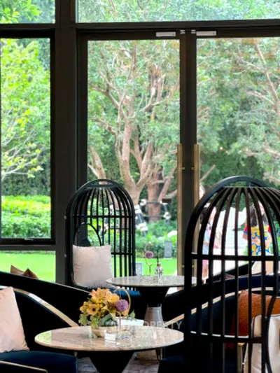 Luxurious living room with modern furniture and large windows overlooking lush greenery.