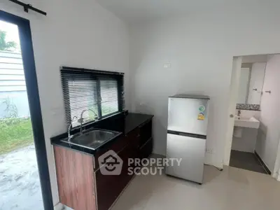 Modern kitchen with sleek design and stainless steel fridge in a bright, compact space.