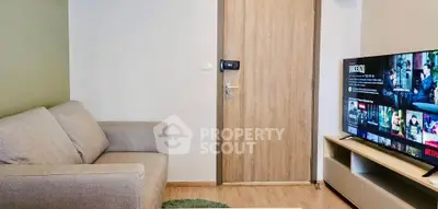 Cozy living room with modern sofa and flat-screen TV, perfect for relaxation and entertainment.