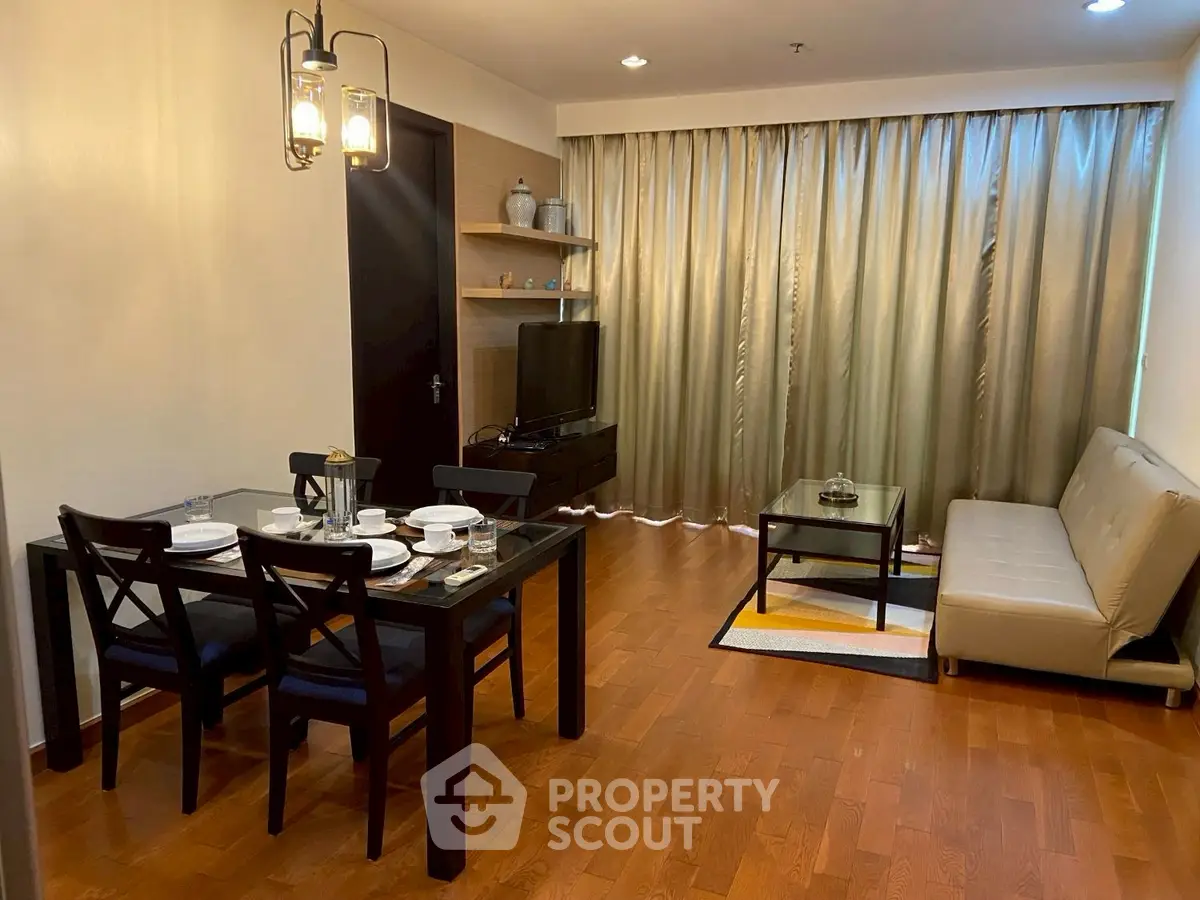 Stylish living room with dining area, wooden flooring, and elegant lighting in modern apartment.