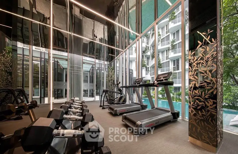 Luxurious gym with modern equipment and pool view in upscale residential building.