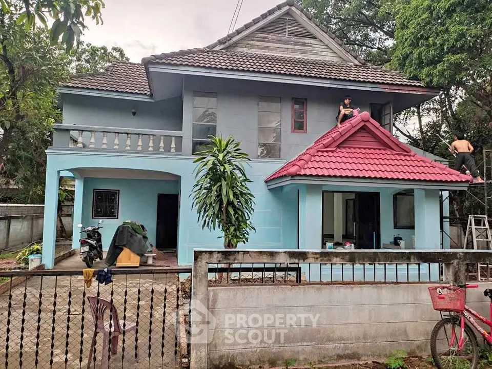 Charming two-story house with a red-tiled roof and spacious front yard, perfect for family living.