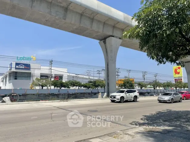 Urban street view with elevated railway and commercial buildings