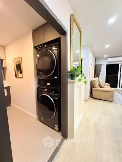 Modern apartment with stacked washer and dryer near cozy living room