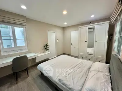 Modern bedroom with sleek design, featuring a cozy bed, built-in wardrobe, and study desk.