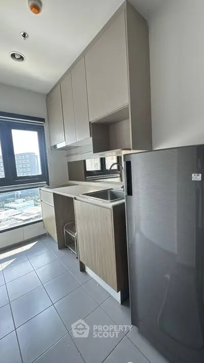 Modern kitchen with sleek cabinetry and stainless steel appliances in a bright apartment.