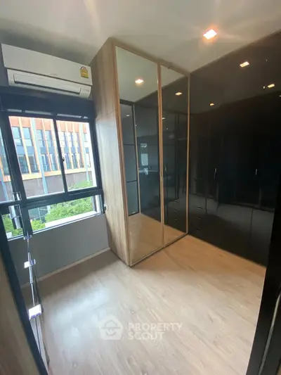 Modern bedroom with sleek black wardrobes and large window view