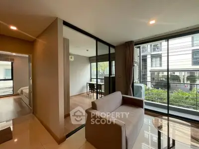 Modern living room with glass partition and balcony view in urban apartment